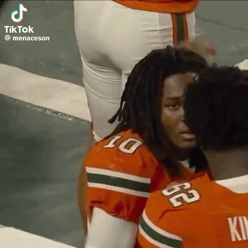 a group of football players are standing next to each other on a field .
