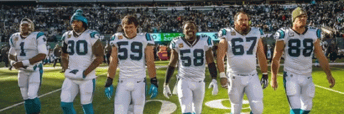A Group Of Football Players Are Standing On A Field And One Has The Number 67 On His Jersey GIF