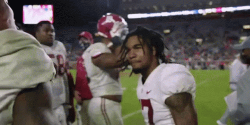 a group of football players are standing on a field and one of them is wearing a number 1 jersey .
