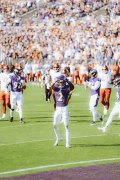 A Group Of Football Players Are Standing On A Field During A Game . GIF