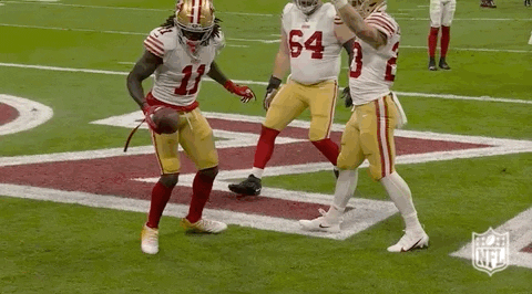 A Group Of Football Players Are Standing On A Field . One Of The Players Has The Number 11 On His Jersey . GIF