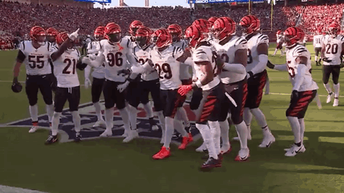 A Group Of Football Players Are Standing On A Field With One Wearing The Number 21 GIF