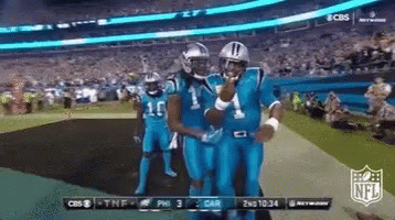 A Group Of Football Players In Blue Uniforms Are Standing On A Field GIF