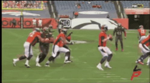 A Group Of Football Players On A Field With A Sign That Says 40 On It GIF