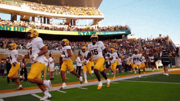 a group of football players running on a field with a sign that says no up