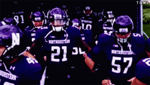 A Group Of Football Players Wearing Purple Uniforms With The Number 52 GIF