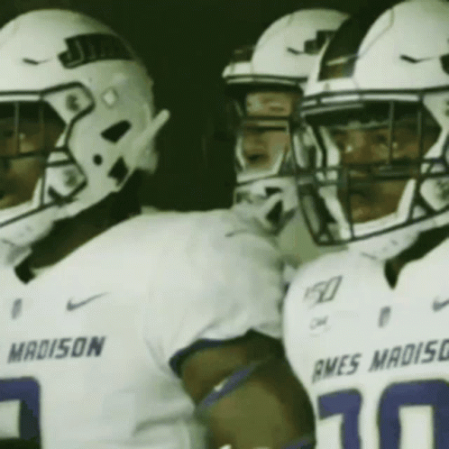A Group Of Football Players Wearing White Uniforms With The Word Madison On The Front GIF