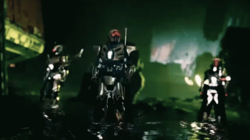A Group Of Futuristic Soldiers Are Standing In A Dark Area GIF