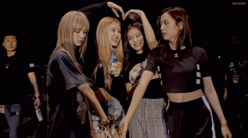 A Group Of Girls Are Posing For A Picture And One Of Them Is Holding A Bottle Of Water GIF