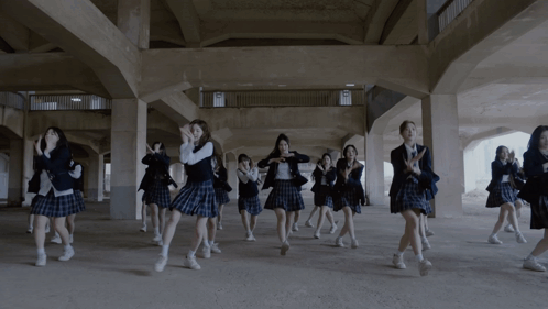 A Group Of Girls In School Uniforms Are Dancing In A Dark Hallway GIF