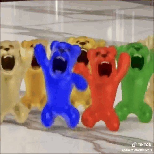 A Group Of Gummy Bears With Their Mouths Open Are Standing Next To Each Other . GIF