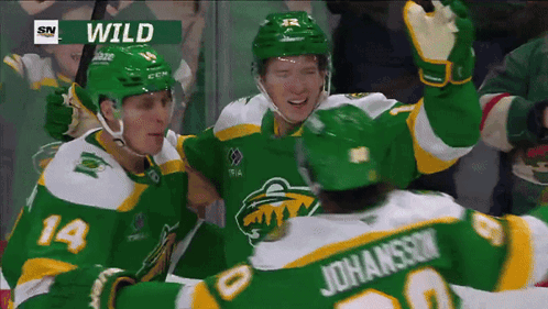 A Group Of Hockey Players Are Celebrating A Goal With The Word Wild On The Screen GIF