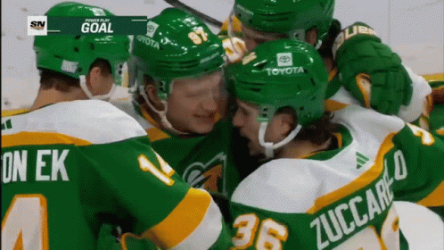 A Group Of Hockey Players Are Huddled Together With One Wearing The Number 36 On His Back GIF