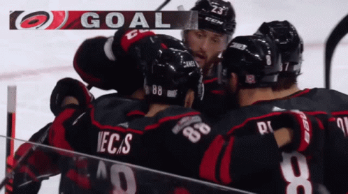 A Group Of Hockey Players Celebrate A Goal With The Letters Goal Above Them GIF