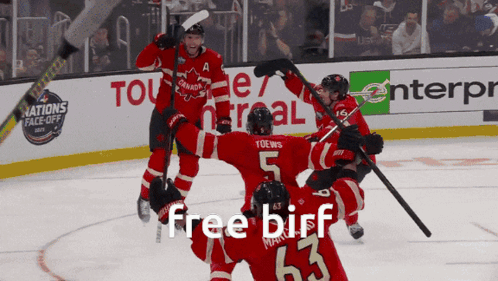 a group of hockey players celebrate a goal with the words free birf on the bottom right