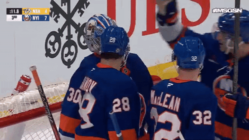 A Group Of Hockey Players Including Number 28 And 32 Are Huddled Together GIF