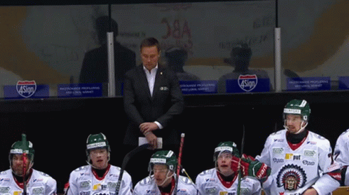a group of hockey players sitting in a locker room with a sign that says 4sign on it