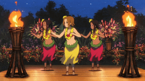 A Group Of Hula Dancers Are Dancing In Front Of Flaming Torches GIF