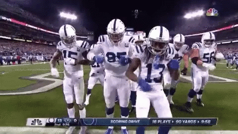 a group of indianapolis colts football players are dancing on the field .