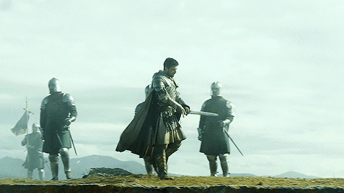 A Group Of Knights Standing On Top Of A Rocky Hill GIF