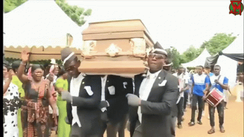 A Group Of Men Are Carrying A Coffin In A Funeral Procession GIF