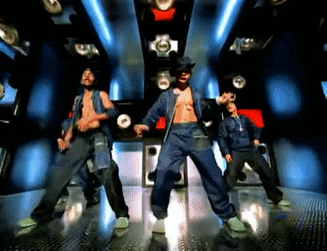 A Group Of Men Are Dancing In A Dark Room With Blue Lights GIF