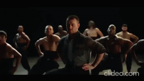 A Group Of Men Are Dancing In A Dark Room With The Words Clideo.com In The Lower Right Corner GIF