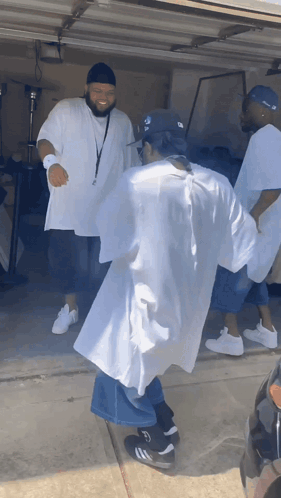A Group Of Men Are Dancing In A Garage With One Wearing A Hat That Says ' Ny Yankees ' On It GIF