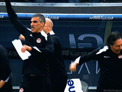 A Group Of Men Are Dancing In Front Of A Banner For The Nations League GIF