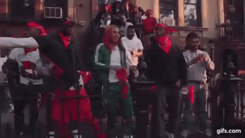 A Group Of Men Are Dancing In Front Of A Building On A City Street . GIF