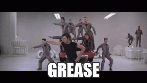 A Group Of Men Are Dancing In Front Of A Car With The Word Grease Written On The Bottom . GIF