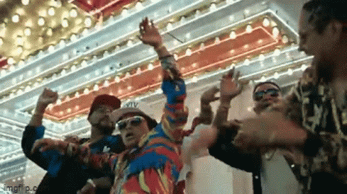 A Group Of Men Are Dancing In Front Of A Colorful Ceiling . GIF