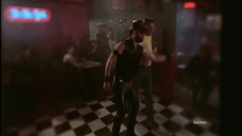 A Group Of Men Are Dancing In Front Of A Neon Sign That Says The Bitter GIF