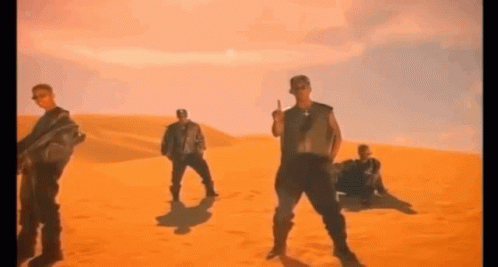 A Group Of Men Are Dancing In The Desert . GIF