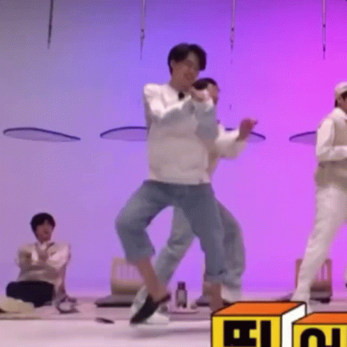 A Group Of Men Are Dancing On A Stage In Front Of A Purple Background . GIF