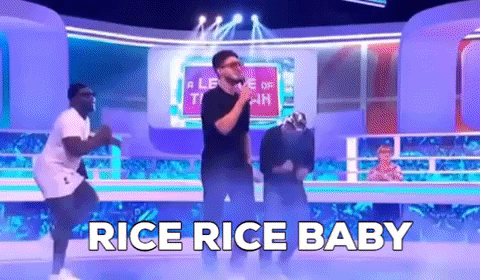 A Group Of Men Are Dancing On A Stage With The Words `` Rice Rice Baby '' Behind Them . GIF