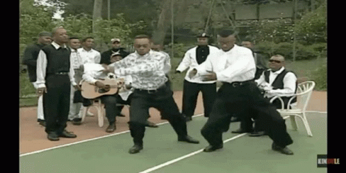 A Group Of Men Are Dancing On A Tennis Court GIF