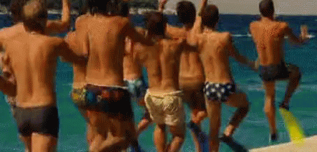 A Group Of Men Are Dancing On The Beach . GIF