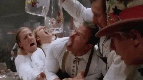 a group of men are drinking beer from a large mug