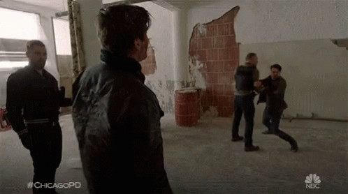 A Group Of Men Are Fighting In A Room With The Hashtag #Chicagopd On The Bottom GIF