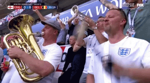 A Group Of Men Are Playing Brass Instruments In A Stadium During A Soccer Game . GIF