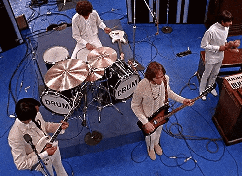 A Group Of Men Are Playing Instruments In Front Of A Drum Set That Says Drum On It GIF