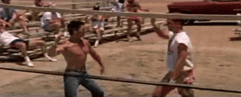 A Group Of Men Are Playing Volleyball On A Beach And One Of Them Is Holding A Volleyball Net . GIF