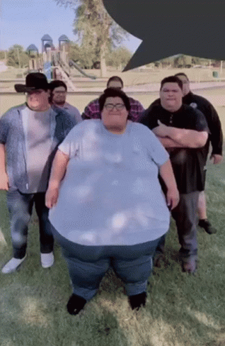 A Group Of Men Are Posing For A Picture With One Of Them Being A Very Large Man GIF