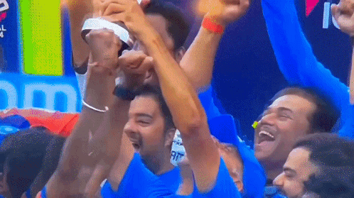 A Group Of Men Are Raising Their Arms In The Air GIF