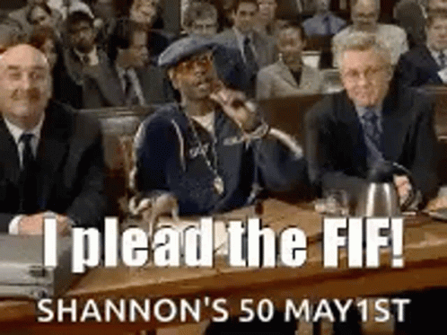 A Group Of Men Are Sitting At A Table In A Courtroom And A Man Is Holding A Microphone . GIF