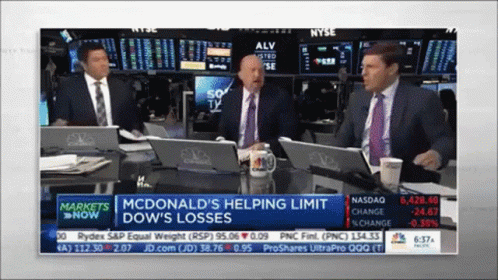 A Group Of Men Are Sitting At A Table With Laptops In Front Of A Screen That Says Markets Now GIF