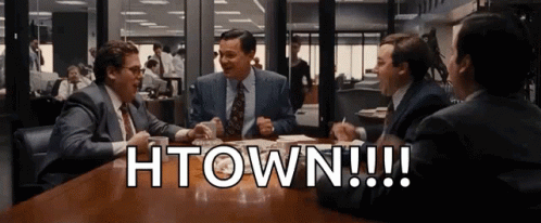 A Group Of Men Are Sitting At A Table With The Words Htown Written On The Table GIF
