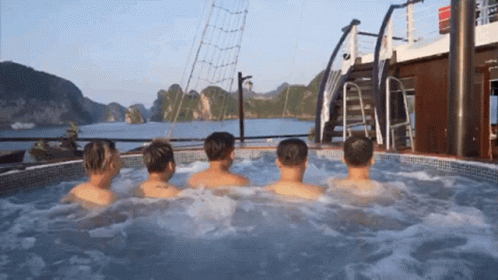A Group Of Men Are Sitting In A Hot Tub On The Deck Of A Boat GIF