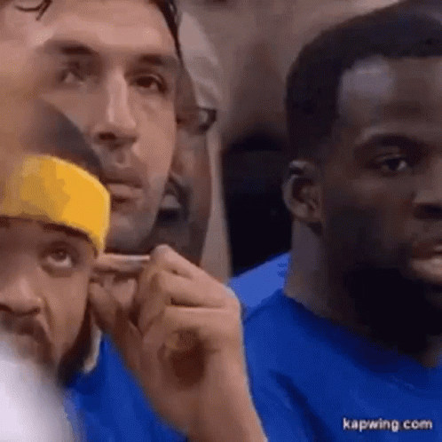 A Group Of Men Are Sitting In A Stadium Watching A Game . GIF